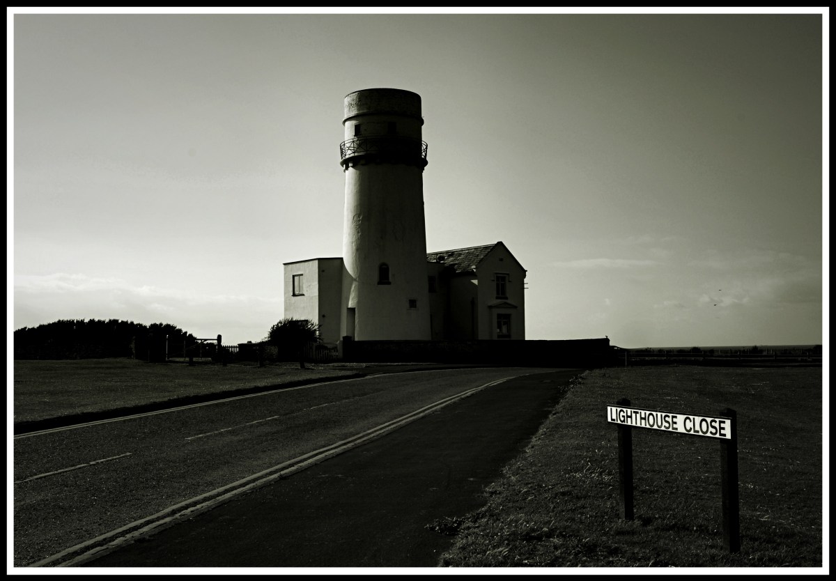 photo taken at the start of lighthouse close with the sign on the lower right and the lighthouse in the centre of the photo