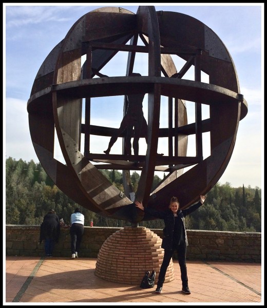 A photo of Sarah doing the same pose in front of The Vitruvian Man